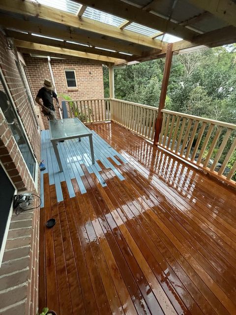 Carpenter oiling a new hardwood deck