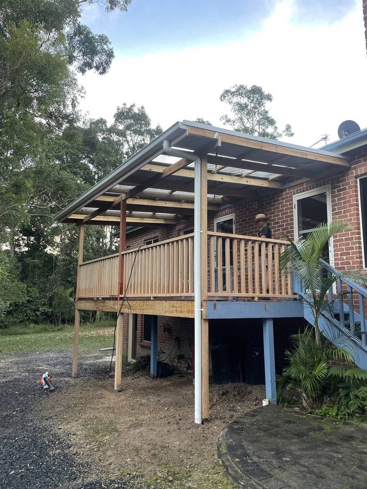 Covered timber deck with a roof on a brick house