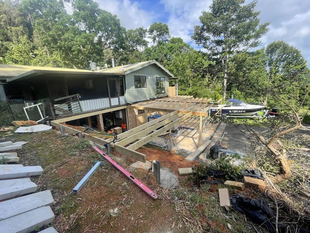 Job site with old timber and building rubbish beside a house